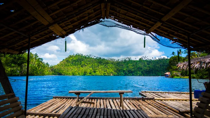 View from a bamboo raft on Pandin Lake, pristine blue water surrounded by lush green hills