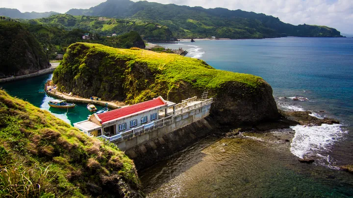 Safety Harbor in Batanes with its red-roofed building perched on green cliffs